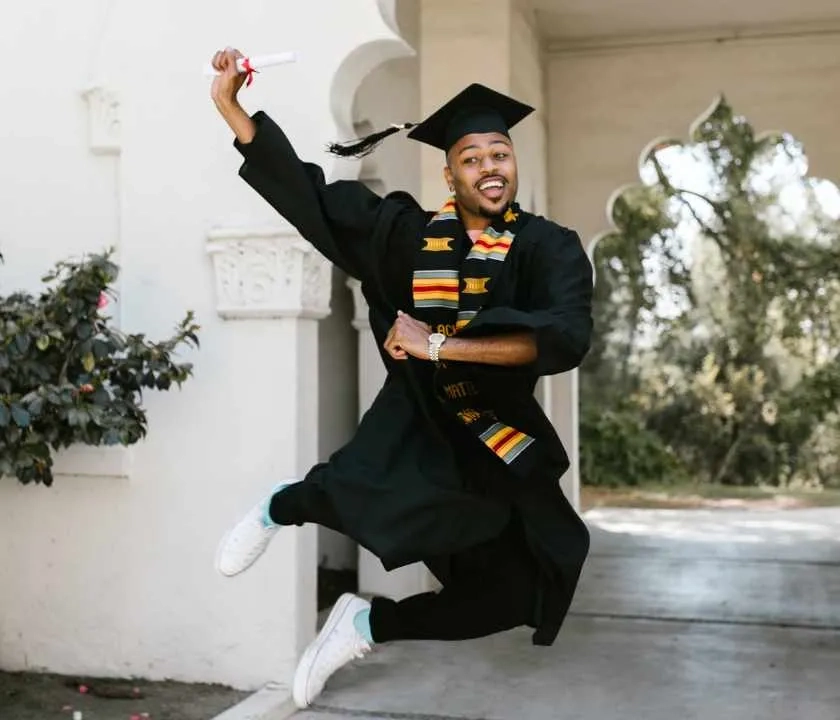 A graduate jumping in the air