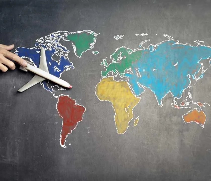 Chalk drawing of world on blackboard with regions coloured in differently